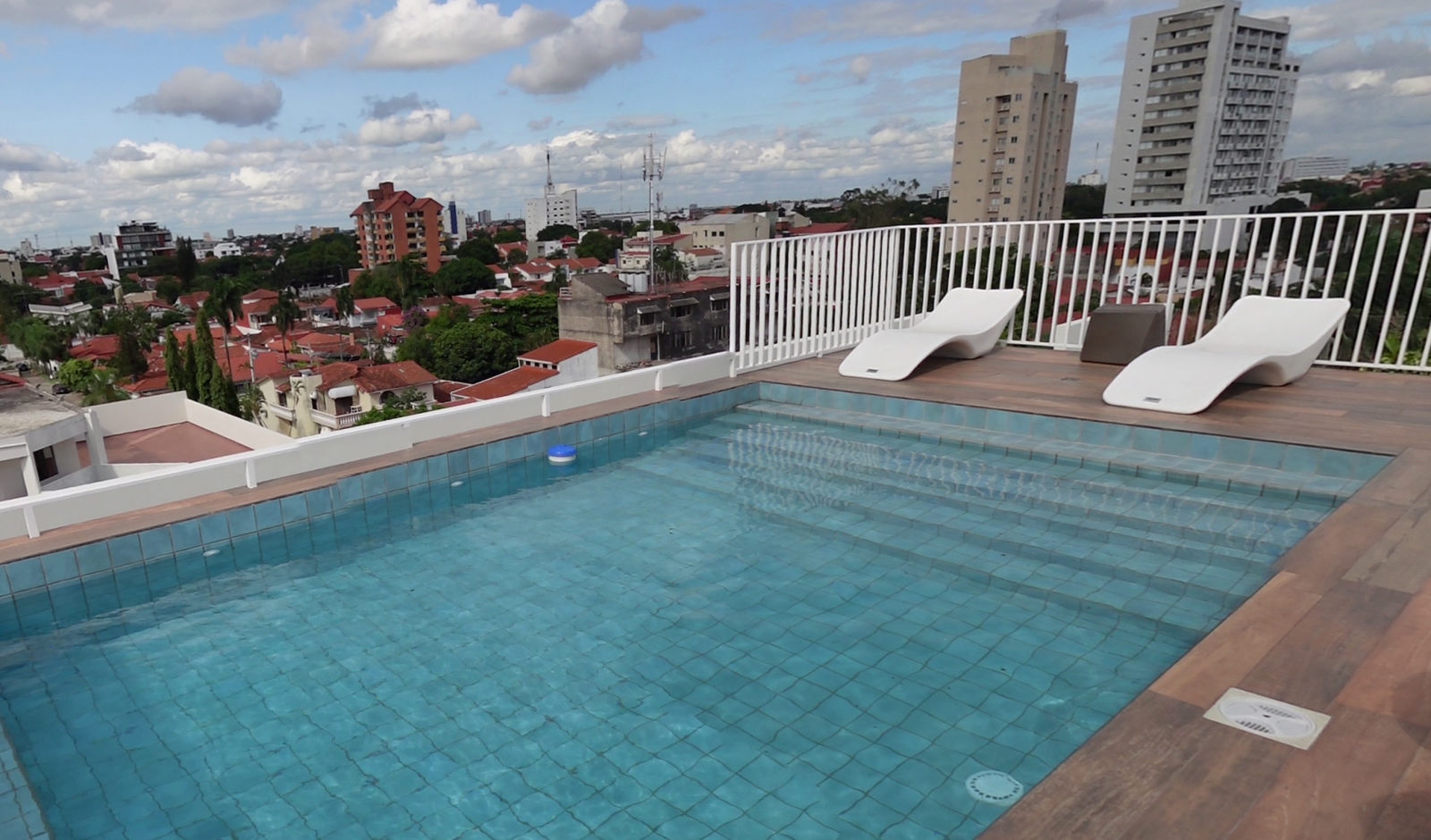 Piscina en la terraza de un edificio Blank con vista a la ciudad