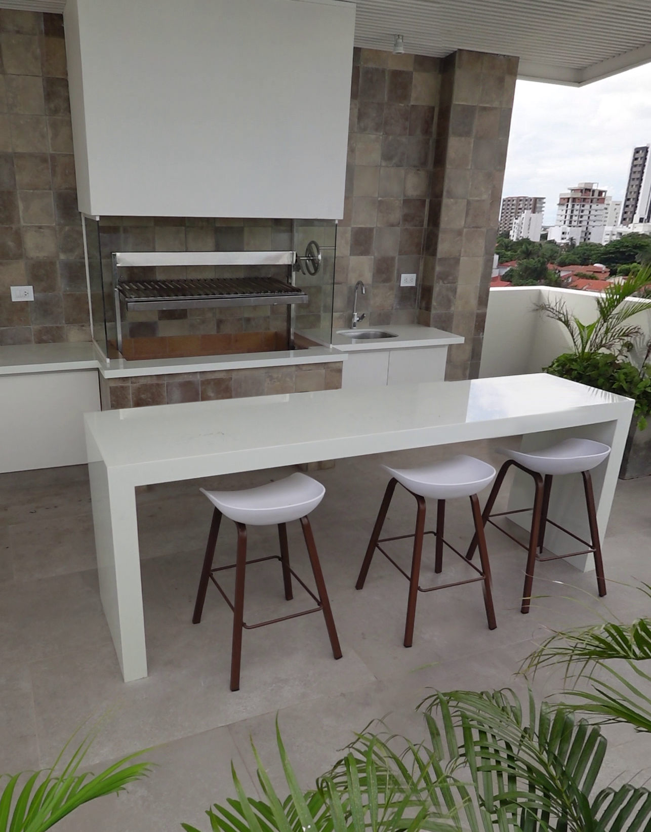Terraza con parrilla y barra de Blank Los Cusis