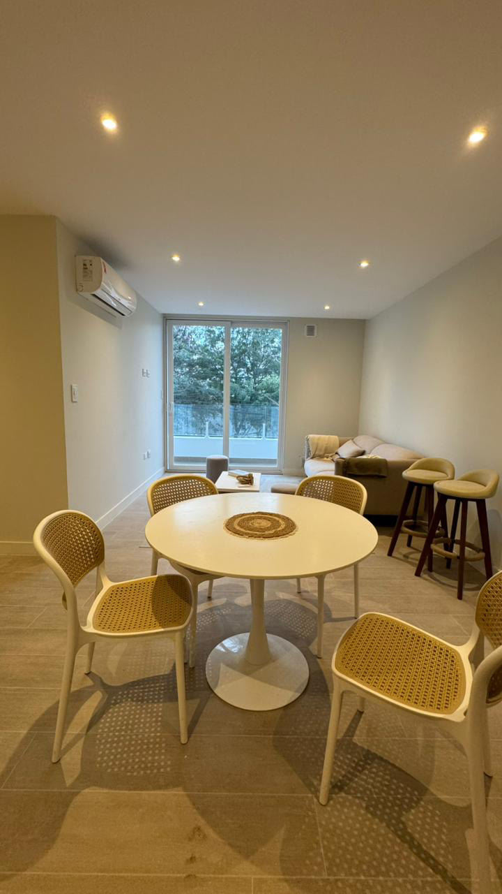 Comedor del departamento modelo, con la cocina al fondo